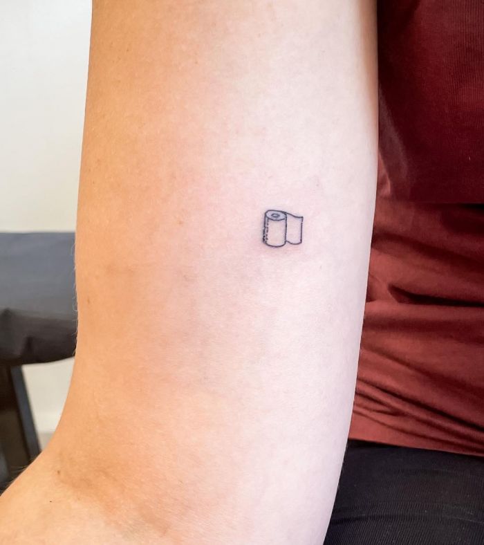 Tiny Toilet Paper Tattoo on Upper Arm