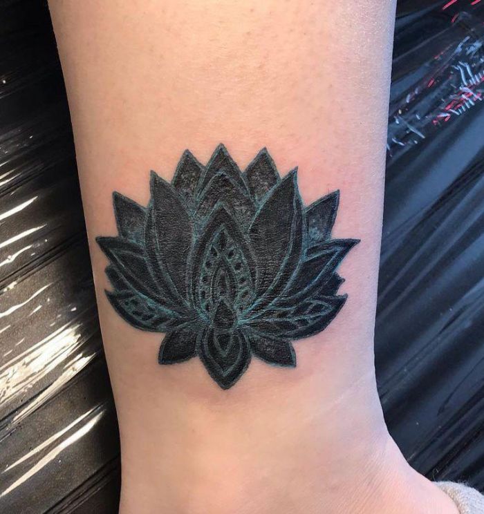 Elegant Black Lotus Tattoo on Lower Leg